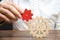 Businessman connects a small red gear to a large gear wheel. Symbolism of establishing business processes and communication.