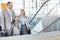 Businessman conversing with female colleague while walking up stairs in train station