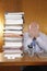 Businessman Covering Face With Hands By Stack Of Folders
