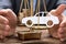 Businessman Covering Paper Car And Coins On Weighing Scale