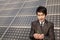 Businessman cupping plant in front of solar panel