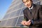 Businessman cupping plant in front of solar panel