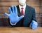 A businessman or Doctor wearing ppe blue gloves and face mask and holding his hand up in a gesture to stop