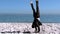 Businessman doing acrobatics on the beach