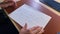 Businessman draws on sheet and writes plan sitting at desk