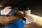 Businessman drinks coffee in a cafe, close-up holds a disposable paper glass, using smartphone while having rest, break or lunch