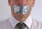 Businessman with duct tape over mouth