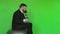 Businessman with dumbbell in hand sits on Exercise ball and talking on phone. Funny situation. Chromakey Green. Bearded