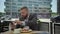 Businessman eating lunch and browsing smartphone, steadicam.