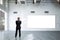 Businessman in an empty room with an empty white board