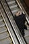 Businessman on Escalator with Cellphone