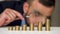 Businessman examines in a magnifying glass columns of coins