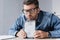 Businessman in eyeglasses holding smashed digital