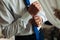 A businessman fastens a cufflink on his wrist watch, the cuff of the sleeve of a luxurious white shirt