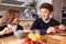 Businessman Father In Kitchen Helping Children With Breakfast Before Going To School