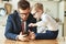 Businessman father with a young schoolboy son looking at a smartphone
