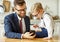 Businessman father with a young schoolboy son looking at a smartphone