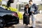 Businessman and female chauffeur near car outdoors