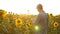 Businessman in field analyzes their income. agronomist studies crop of a sunflower. A farmer man works with a tablet in