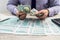 A businessman fills out an individual 1040 tax form and counts dollars. Male hands writing on paper with calculator in office