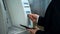 Businessman finishing banking transaction, removing card from ATM, banking