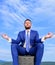 Businessman formal suit sit on briefcase and meditating outdoors. Man try to keep his mind clear. Relaxation technique