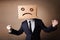 Businessman gesturing with cardboard box on his head with sad fa