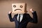 Businessman gesturing with cardboard box on his head with sad fa