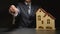 Businessman gives a keys near a house model on a table