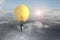 Businessman in glowing yellow lightbulb hot air balloon flying