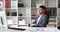 Businessman in gray jacket sitting at table in white office, looking at clock and leaving on office-chair