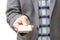 Businessman in grey suit shows business card with copy space