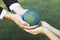 Businessman hand giving Earth globe to little boy as Earth day concept. Gyre