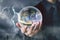 Businessman hand hold crystal ball with city night inside