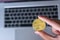 Businessman hand holding golden Dash Cryptocurrency coin over keyboard laptop, Crypto is Digital Money within the blockchain