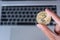 Businessman hand holding Golden Zcash ZEC cryptocurrency coin over laptop keyboard, Crypto is Digital Money within the