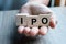 Businessman hand holding IPO Initial Public Offering word with wooden cube block, shares of a private corporation to the public