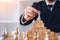 Businessman hand picking chess on top block wood about leadership concept.