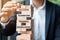 Businessman hand placing or pulling wooden block on the tower with text; Success, Teamwork, Training and Knowledge. Business