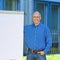 Businessman With Hand In Pocket Standing By Flipchart