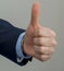 Businessman hand showing okay sign. On grey background.