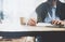 Businessman handing pencil hand and writing message. Blurred background, horizontal mockup.