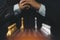 Businessman hands in black suite sitting and clasping hands planning strategy with chess on vintage table. Decision and achievemen