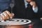 Businessman hands in black suite sitting and holding black dart put to centre of target board on vintage table meaning of investme