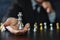 Businessman hands in black suite sitting and holding chess king on vintage table meaning of planning and strategy. Decision and ac