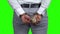 Businessman hands in handcuffs holding US dollars.