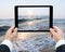 Businessman hands tablet taking pictures beach and sea