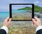 Businessman hands tablet taking pictures beach and sea