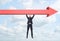 Businessman hanging freely on giant red arrow