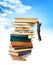 Businessman hanging on top of stack books